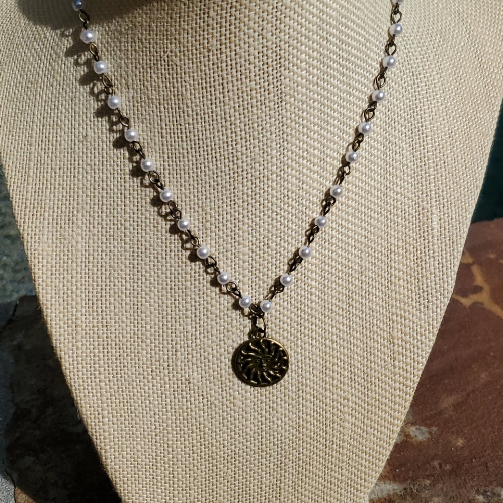 Bronze plated pearl necklace with Sunburst charm.